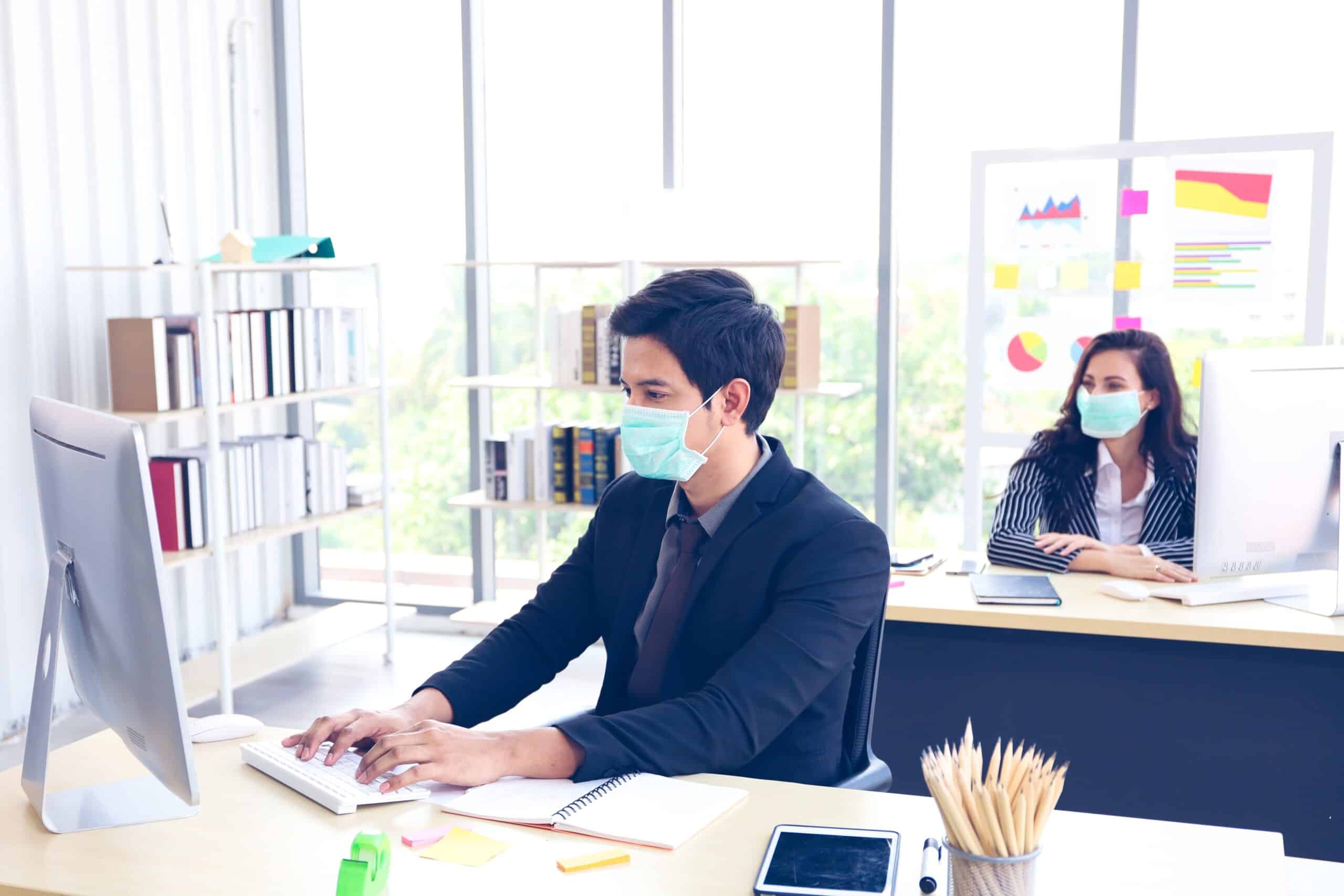 Workers in office wearing face masks.